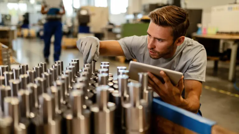Worker examining metal fittings
