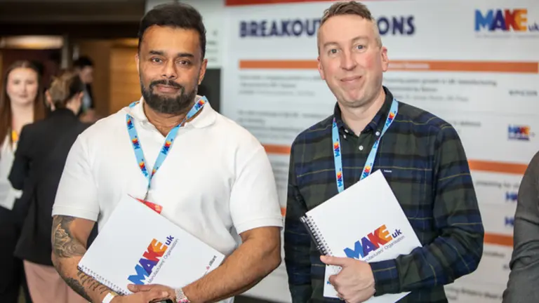 Image of two Make UK colleagues at exhibition smiling
