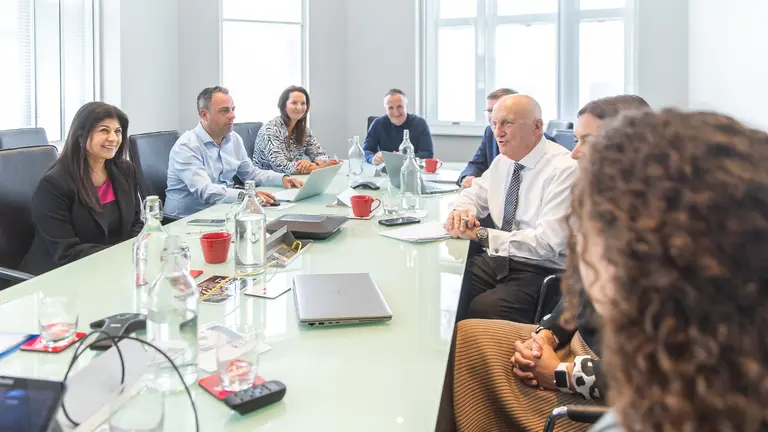 Image of board members in discussion around board table