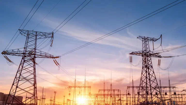 Power transmission towers at sunset with a warm glow.