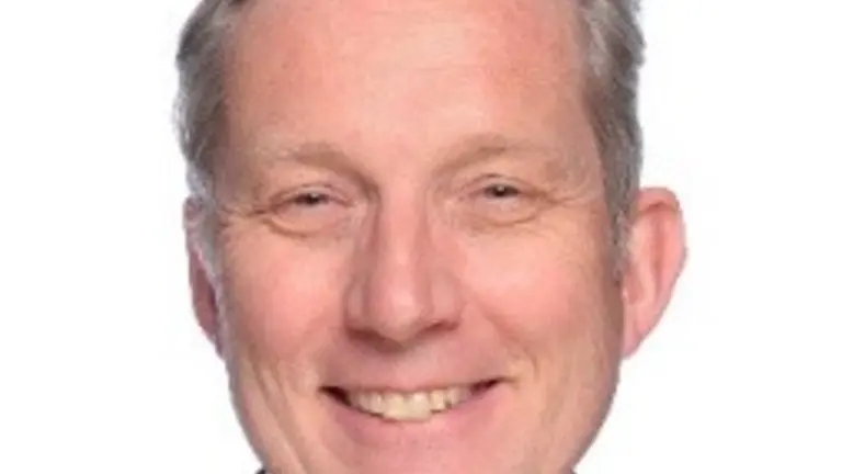 Man in business suit and striped tie smiling for the camera.