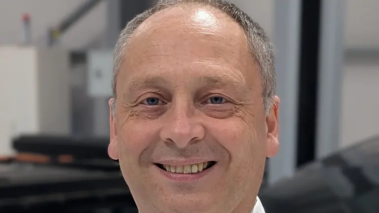 Man in a white shirt smiling for the camera 