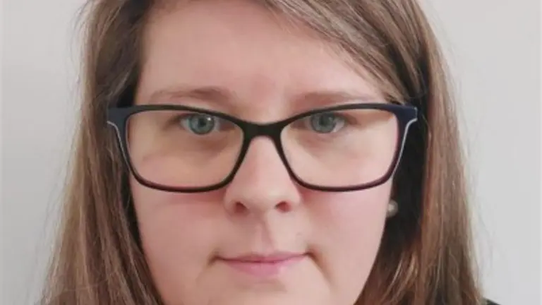Woman with glasses, smiling at the camera.