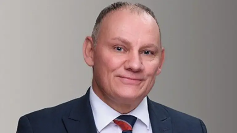 A man in business attire smiling for the camera.