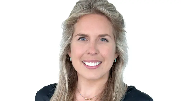Woman in professional attire smiling at the camera.