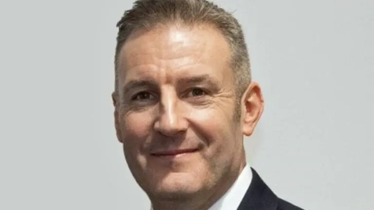Man in suit and tie smiling at camera.
