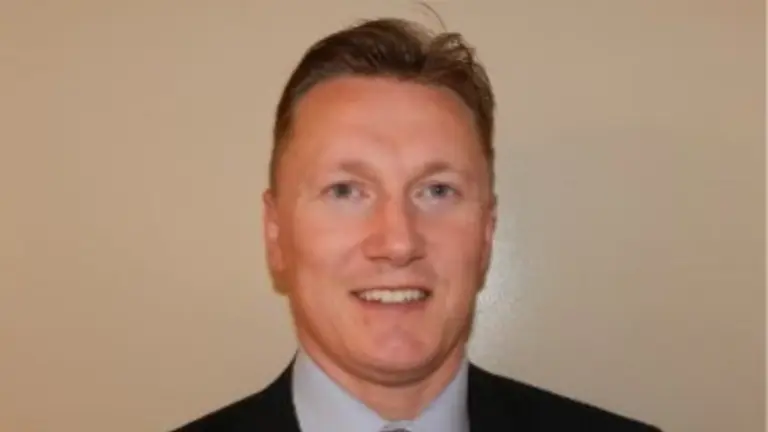 Man in business suit smiling at camera.