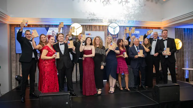 A group of people on a stage holding awards.