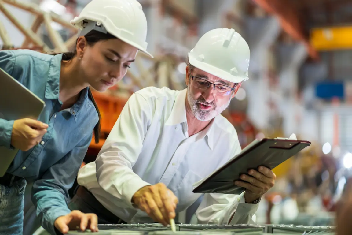 Two workers examine tablet