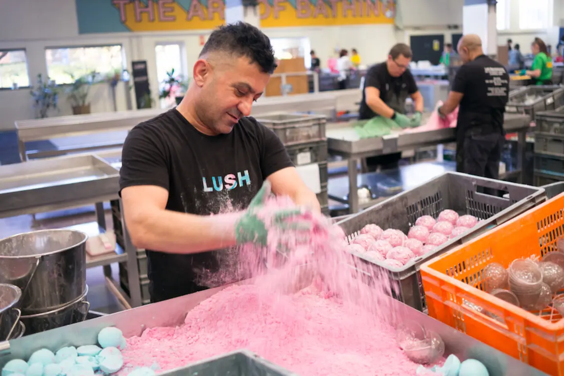 A man working during NMD at Lush pouring pink bubble bath.