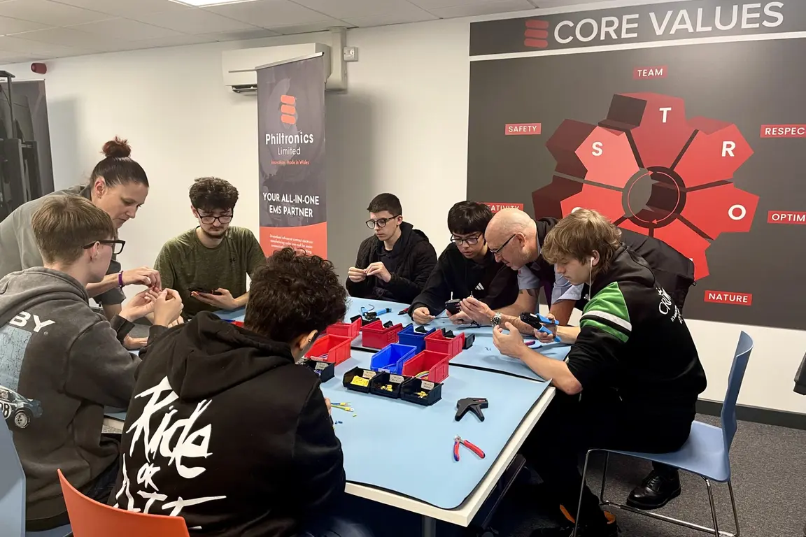 Students gathered around a table working on an electronic project for national manufacturing day 2025.