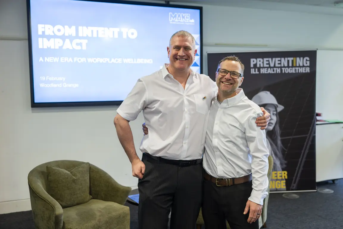Two Health & Safety colleagues standing together smiling