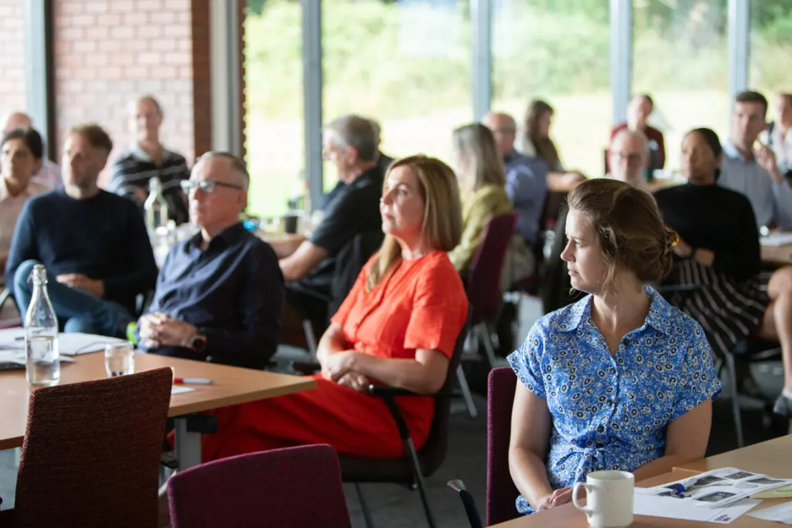 Delegates sitting listening carefully to a presenter at an event