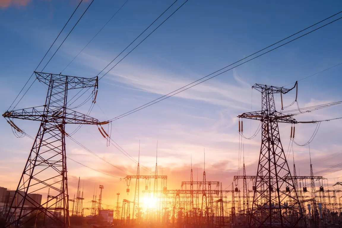 Power transmission towers at sunset with a warm glow.