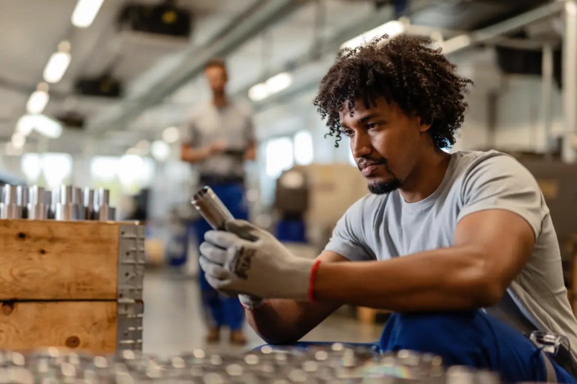 Worker examining metal fittings