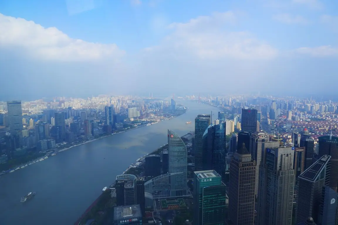 Aerial view of a city in China with many skyscrapers and a river in the foreground.