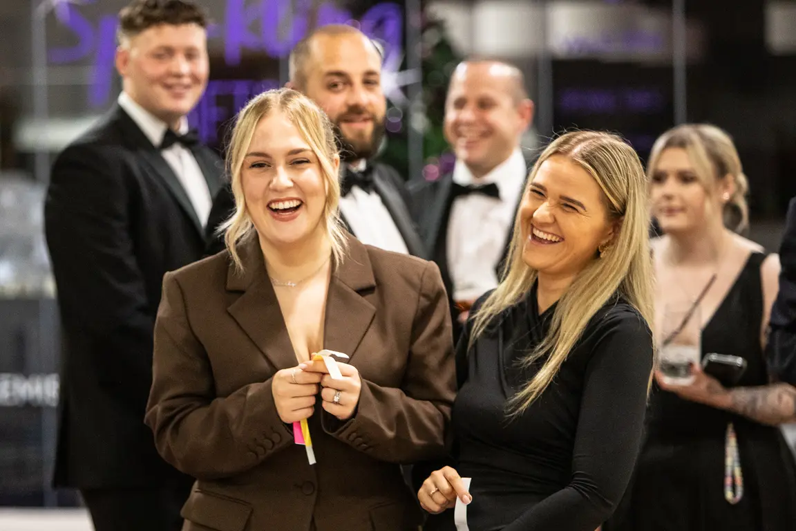 Group of people together at an event, smiling and laughing.