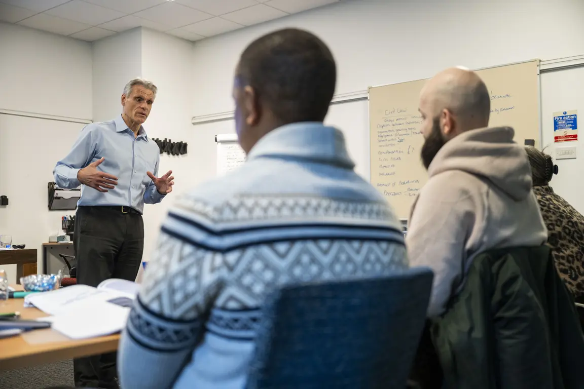 Man giving a presentation to others in a classroom setting.