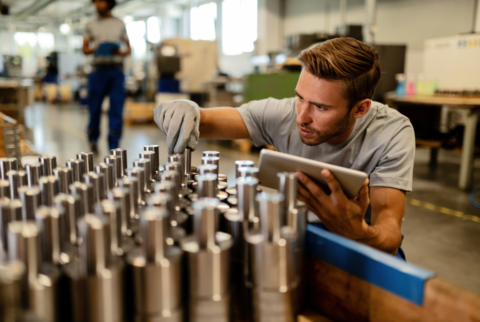 Worker examining metal fittings
