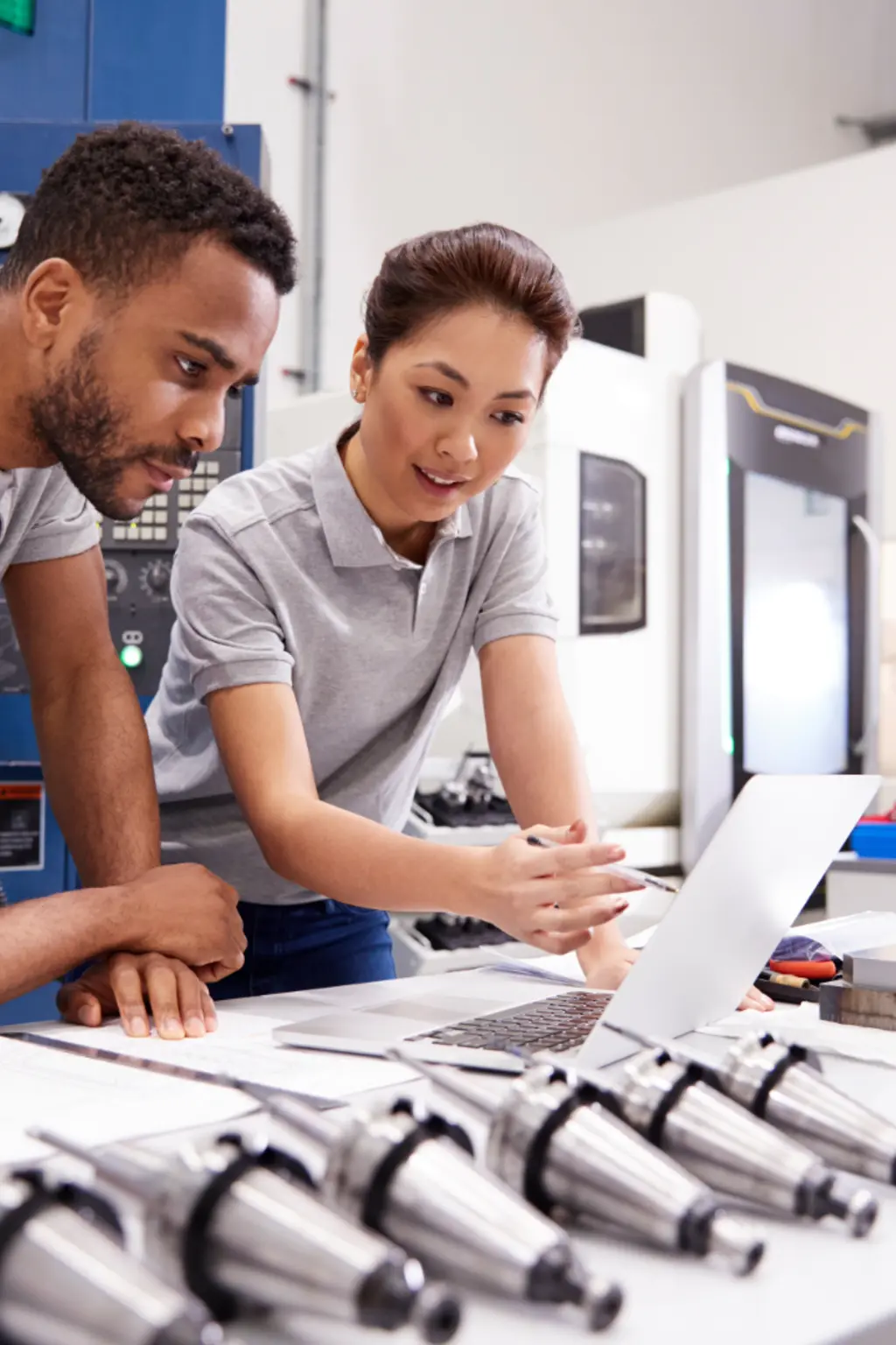 Two manufacturers examine computer in factory