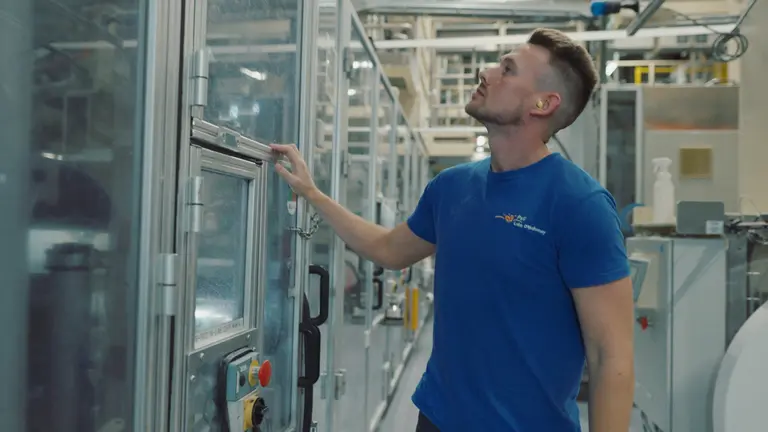 Male factory worker examining Pampers products