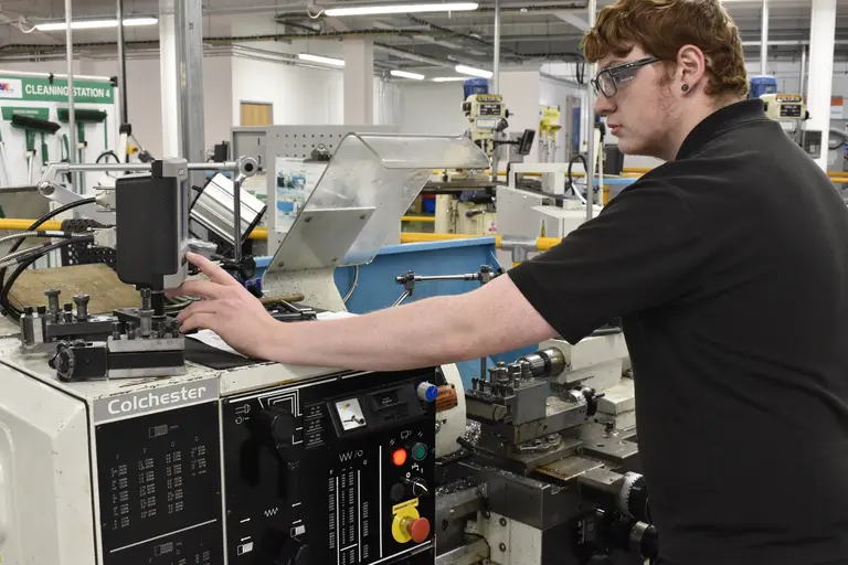 A man in a factory working on a large machine.