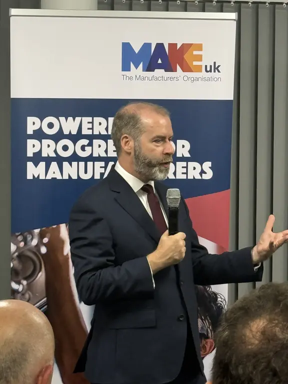 Jonny Reynolds speaking in front of Make UK banner