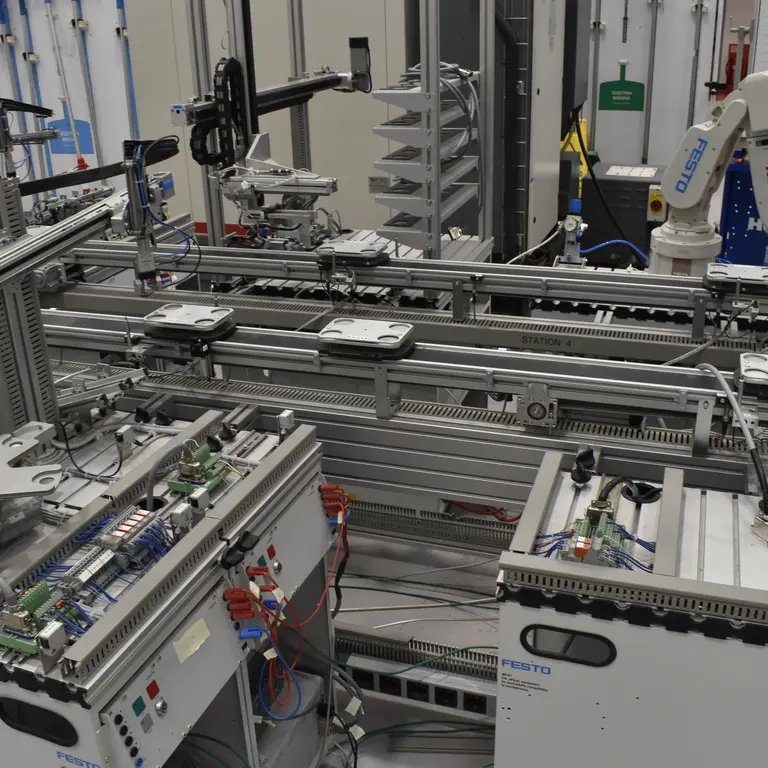 Production line with multiple machines and robotic arms working on assembling electronic components.