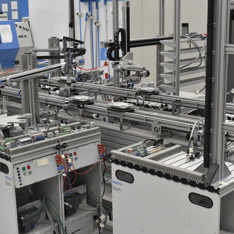 Rows of machinery in a factory with cables and wires.